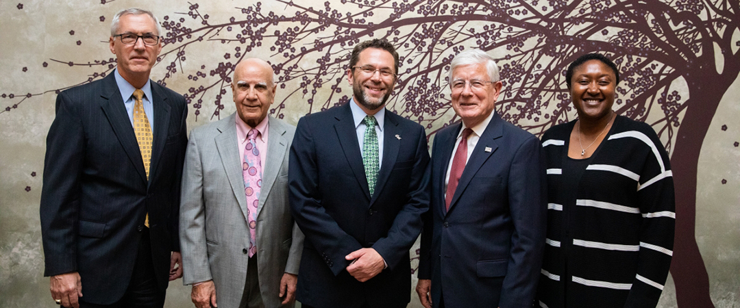 Group of five people standing and posing