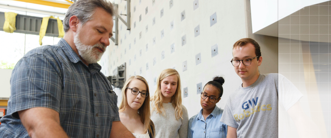 four students watching demonstration in the machine shop