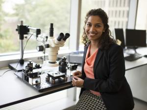 Saniya Leblanc posing with a microscope
